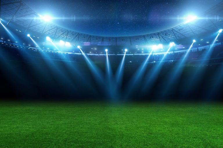 Professional soccer stadium with beautiful green grass field illuminated by blue spotlights at night