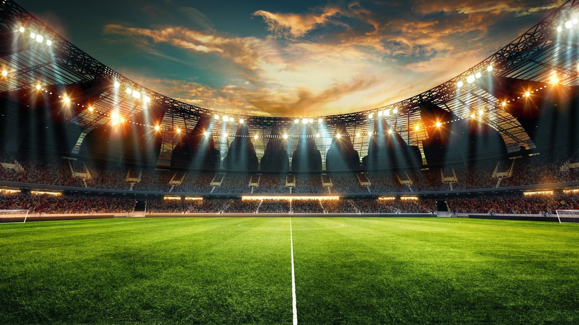 Modern football stadium with bright floodlights illuminating the pitch against a sunset sky