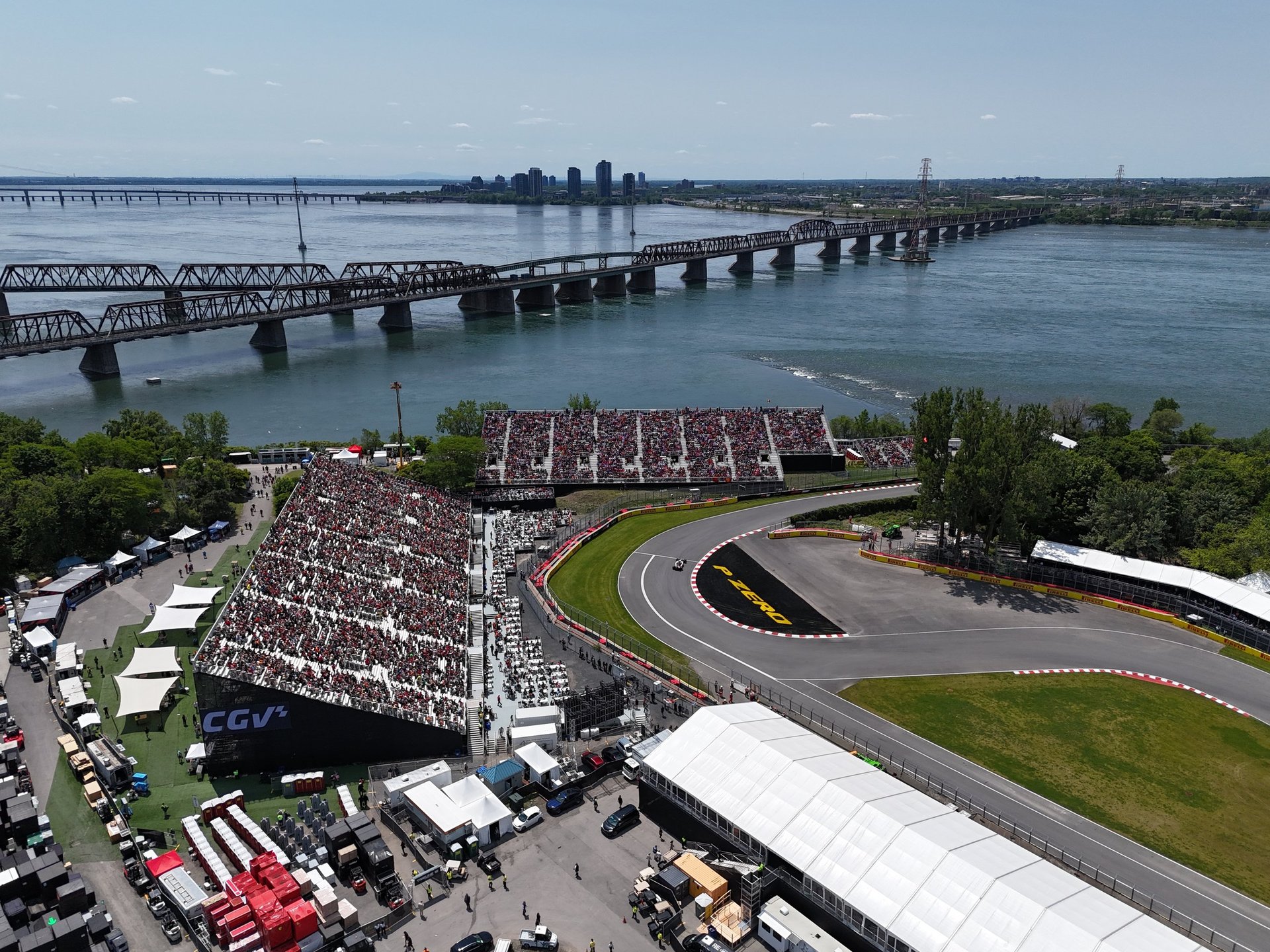 Helicopter flight over an F1 circuit with crowded grandstands and city skyline
