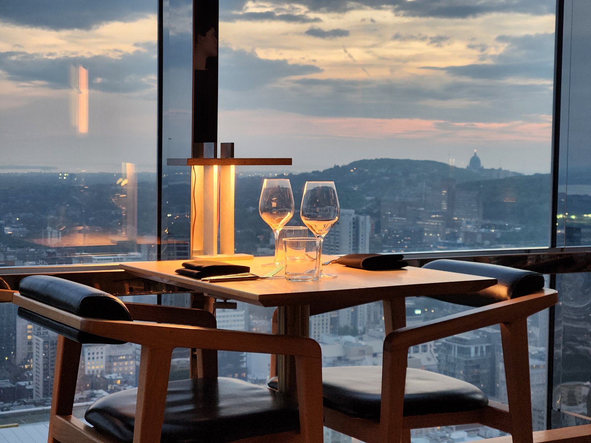 Elegant table by a window overlooking a city skyline at sunset