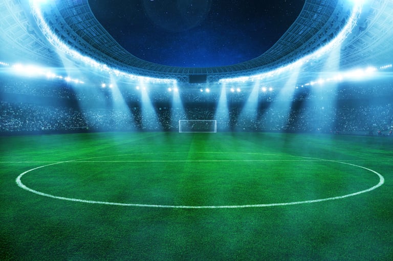 Modern floodlit football stadium at night