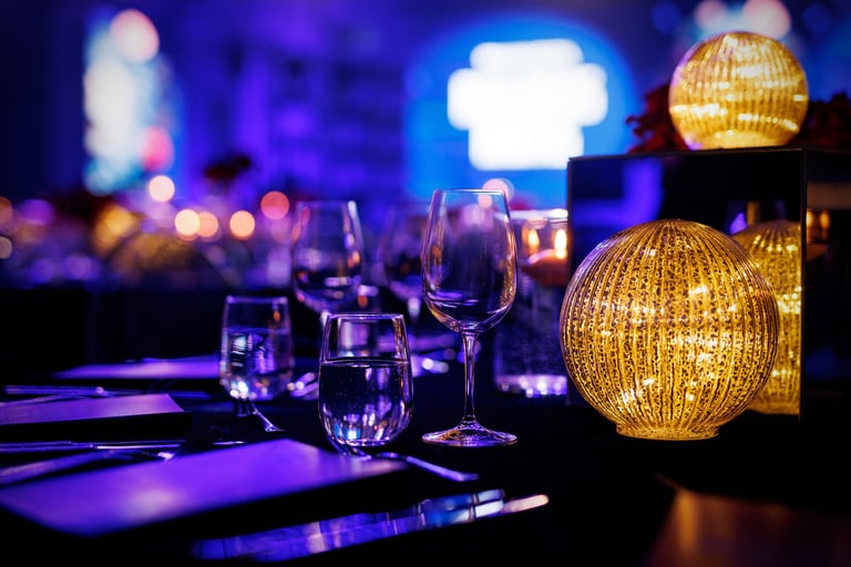 Gala dinner table with polished cutlery and a glowing lamp