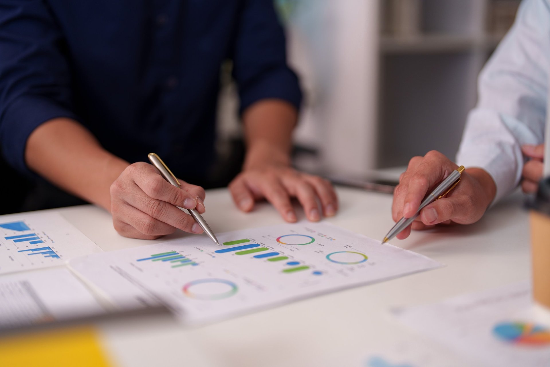 Professionals reviewing printed charts and graphs during a strategy review