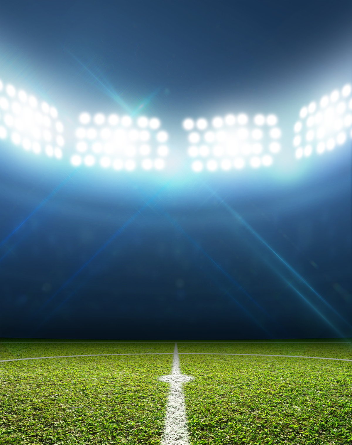 Football stadium with floodlit pitch at night