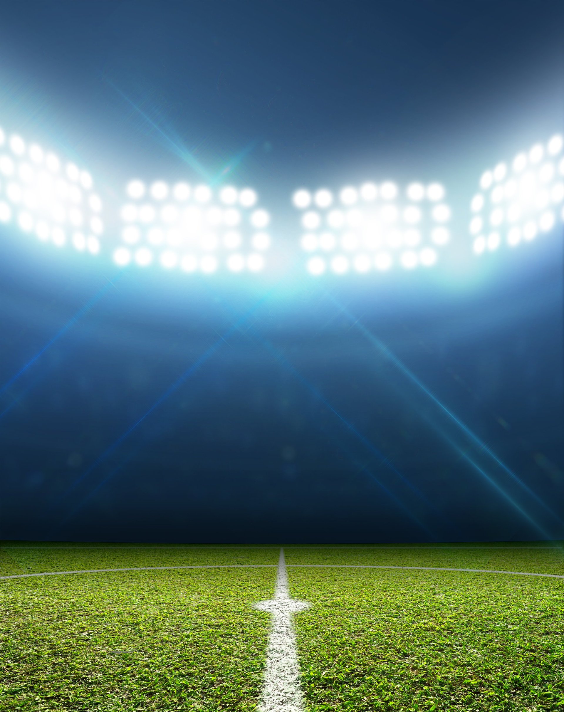 Football stadium with floodlit pitch at night